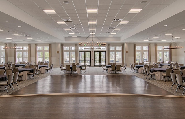 gym with french doors, plenty of natural light, wood-type flooring, and a drop ceiling