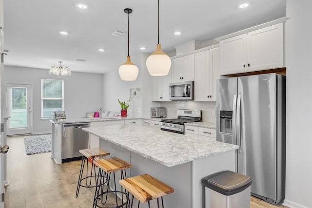 136 Rowans Creek Dr, Charleston, SC 29492 - kitchen with appliances with stainless steel finishes, a peninsula, light wood-style floors, white cabinets, and recessed lighting