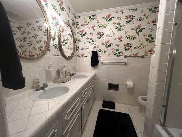 bathroom featuring tile patterned flooring, toilet, crown molding, a shower with door, and vanity