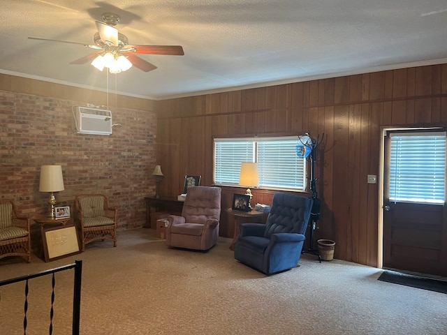 carpeted living room with ceiling fan, a textured ceiling, wooden walls, and ornamental molding