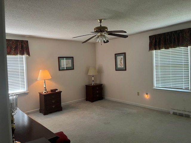 unfurnished room featuring light carpet, a textured ceiling, and ceiling fan