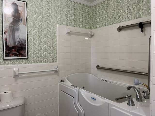 bathroom featuring a bathing tub, crown molding, tile walls, and toilet