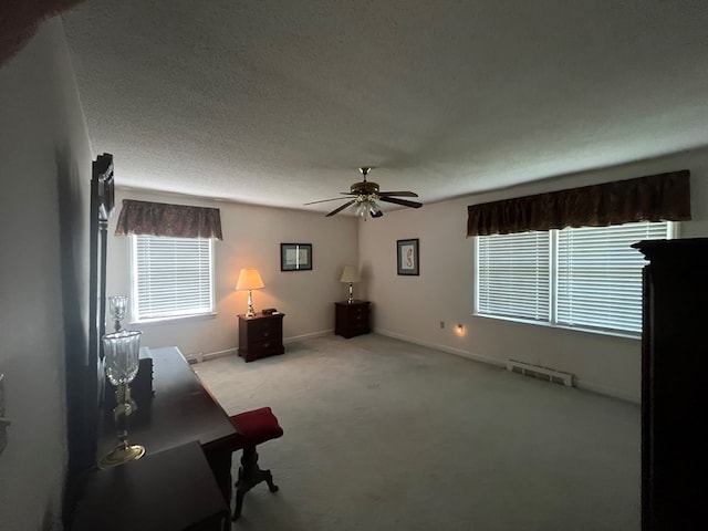 interior space featuring light carpet, ceiling fan, and a textured ceiling