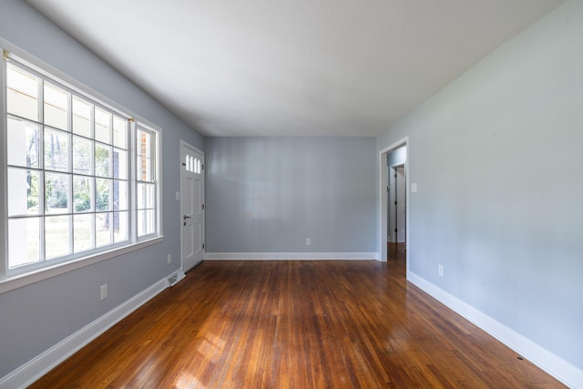 unfurnished room with dark wood-type flooring