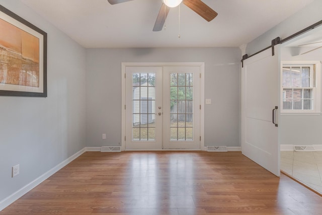 doorway featuring plenty of natural light, a barn door, and light hardwood / wood-style flooring