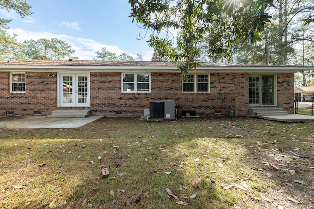 rear view of property featuring french doors, a yard, a patio, and central AC unit