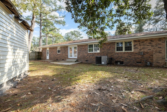 rear view of property with cooling unit, a yard, a patio, and french doors