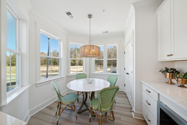 dining space featuring light hardwood / wood-style flooring and ornamental molding