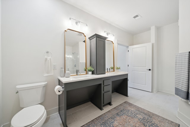 bathroom featuring vanity, a shower, tile patterned flooring, and toilet