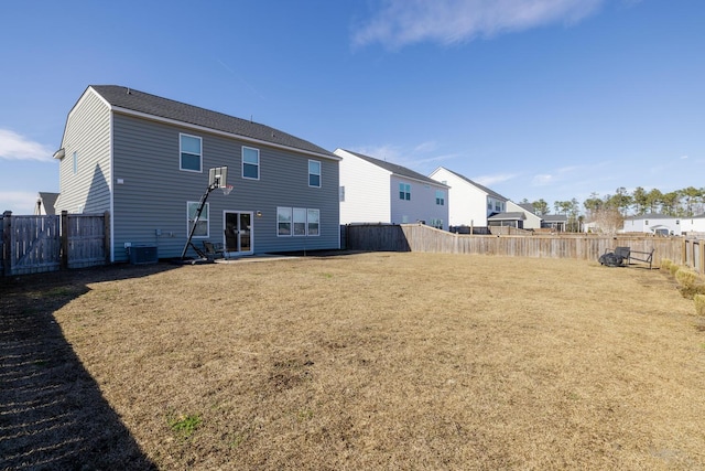 back of property with a yard and central AC unit