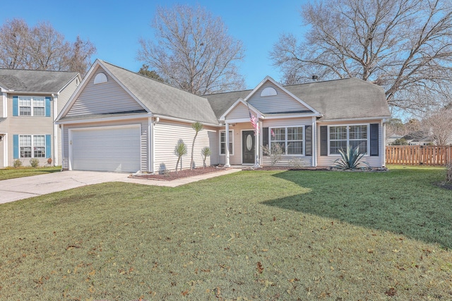 traditional-style home with roof with shingles, an attached garage, a front yard, fence, and driveway