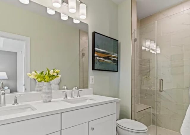 full bathroom with toilet, a stall shower, and double vanity
