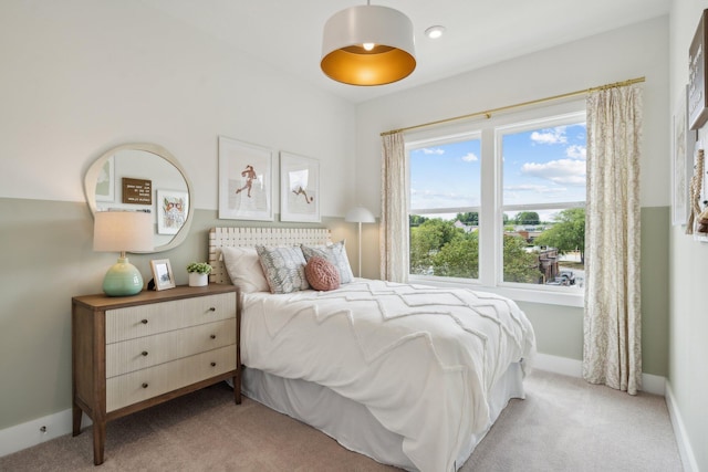 bedroom with light carpet and baseboards