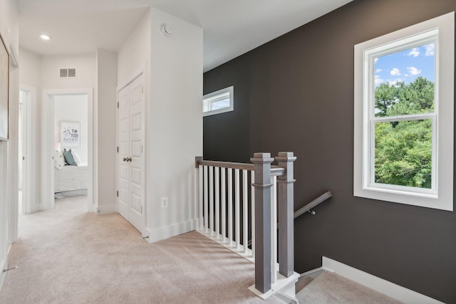 hallway with an upstairs landing, healthy amount of natural light, carpet floors, recessed lighting, and baseboards
