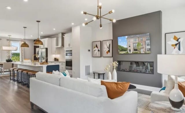 living area featuring dark wood finished floors, recessed lighting, and a chandelier
