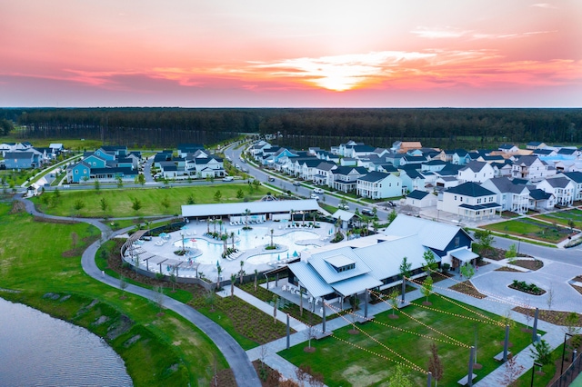 aerial perspective of suburban area with a large body of water and a pool