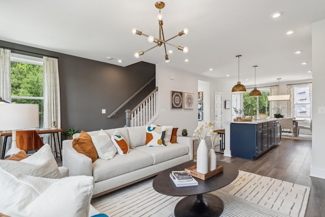 living area featuring dark wood-type flooring, stairs, a chandelier, and recessed lighting