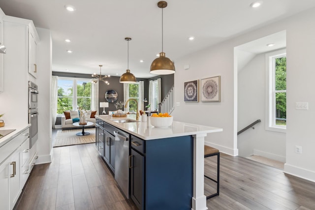 kitchen with a sink, appliances with stainless steel finishes, healthy amount of natural light, white cabinets, and recessed lighting