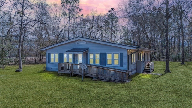 view of front of property featuring a wooden deck and a yard