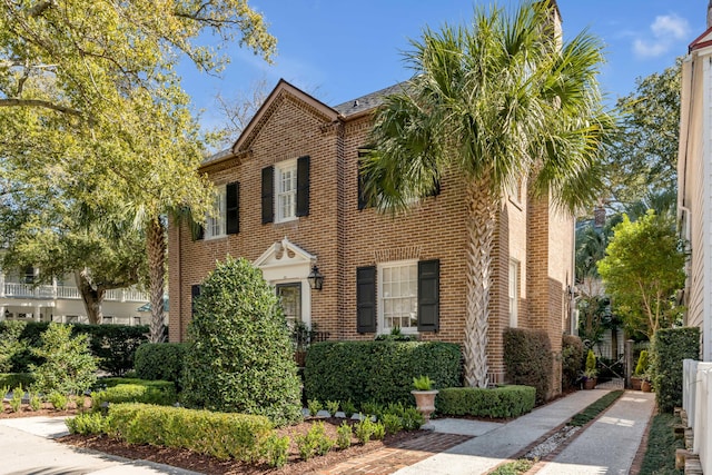 view of front of home featuring brick siding and fence