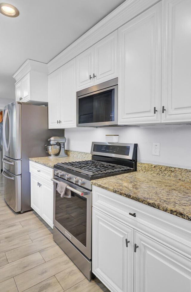1861 Jaywood Cir, Charleston, SC 29407 - kitchen featuring stainless steel appliances, light wood-style flooring, white cabinetry, and light stone counters
