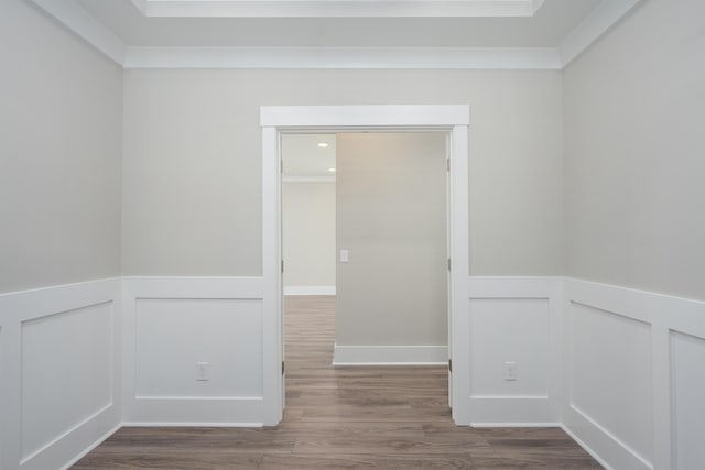 empty room with wainscoting, a decorative wall, and wood finished floors