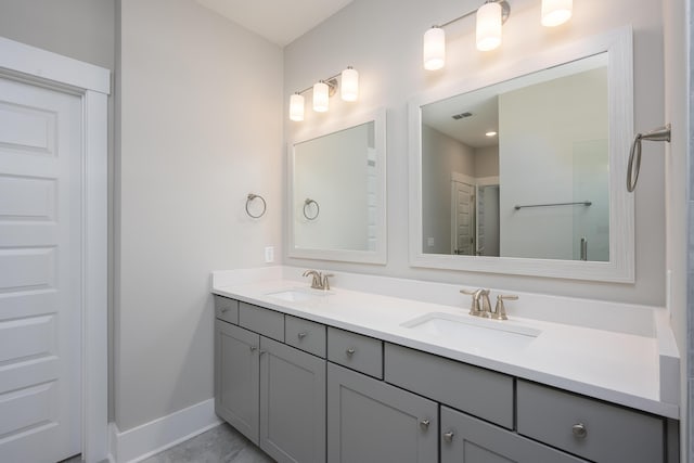 bathroom with baseboards, visible vents, a sink, and double vanity