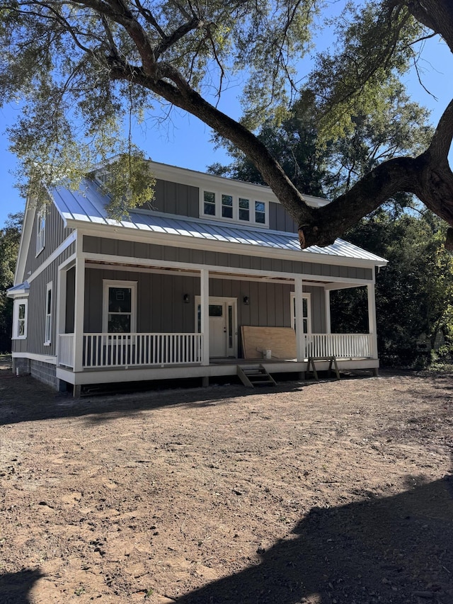 view of front of house with covered porch, metal roof, board and batten siding, and a standing seam roof