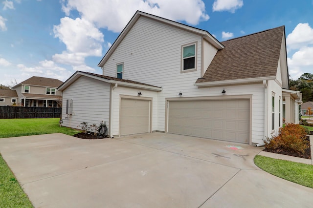 view of side of property with a garage and a lawn