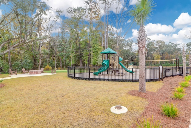 view of jungle gym featuring a yard and an outdoor fire pit