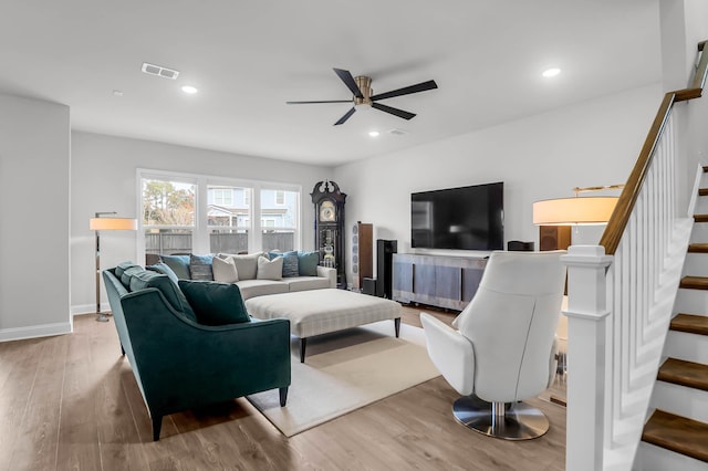 living room with ceiling fan and light hardwood / wood-style flooring