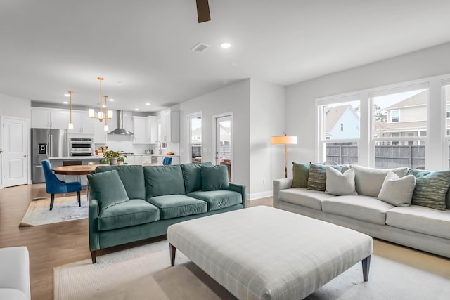 living room featuring a notable chandelier and light wood-type flooring