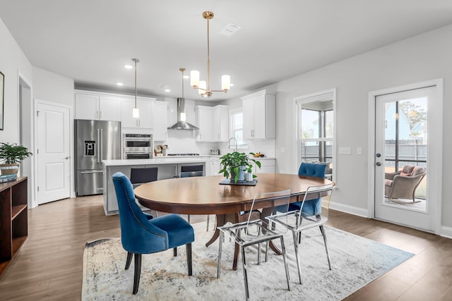 dining space featuring a chandelier, wood-type flooring, and sink