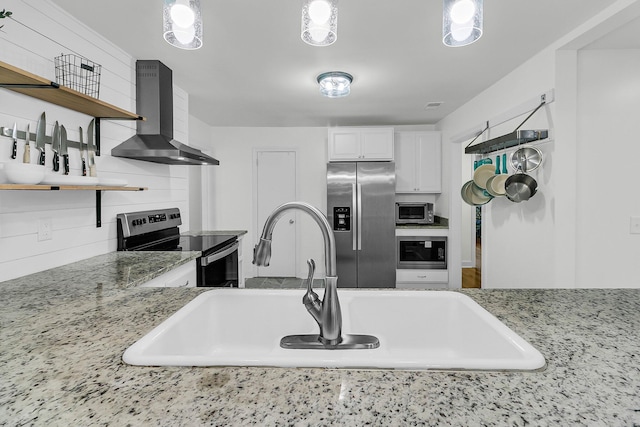 1909 Swift Ave, Charleston, SC 29407 - kitchen with appliances with stainless steel finishes, wall chimney range hood, open shelves, white cabinetry, and light stone counters