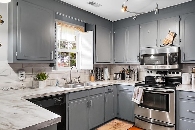 8692 Bentwood Dr, North Charleston, SC 29406 - kitchen featuring stainless steel appliances, gray cabinets, light countertops, and decorative backsplash
