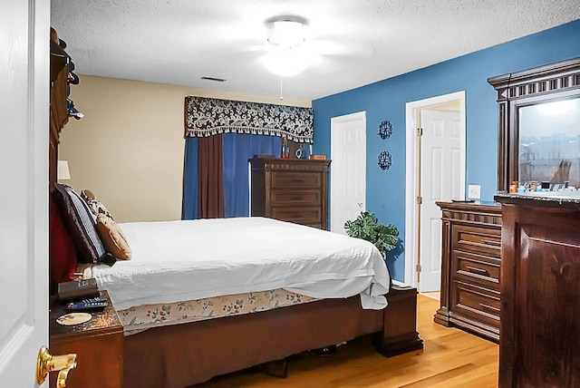 8692 Bentwood Dr, North Charleston, SC 29406 - bedroom with light wood-type flooring, a textured ceiling, and ceiling fan