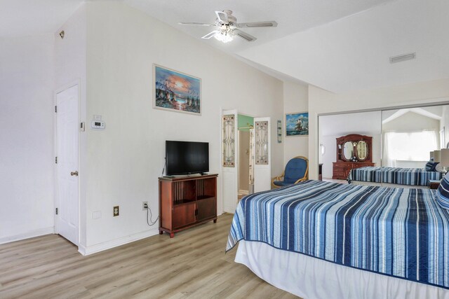 bedroom featuring ceiling fan, a closet, light hardwood / wood-style floors, and lofted ceiling