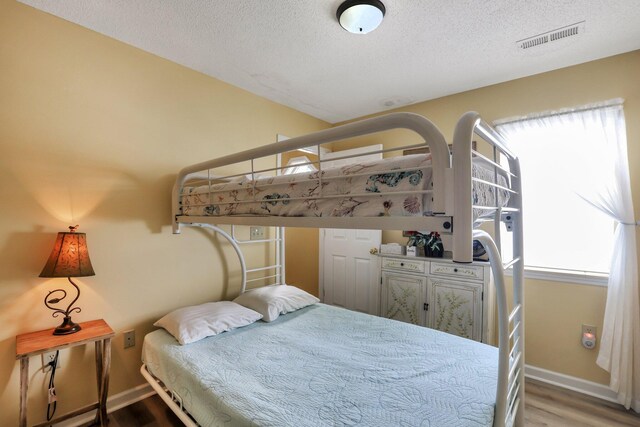 bedroom featuring lofted ceiling and light wood-type flooring