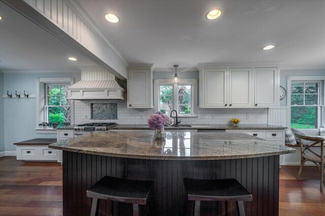 375 Seewee Cir, Mount Pleasant, SC 29464 - kitchen featuring stainless steel range with gas cooktop, a kitchen breakfast bar, decorative backsplash, a sink, and dark stone counters