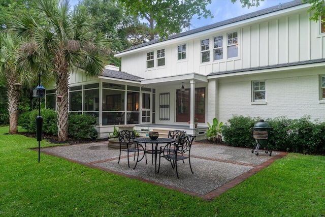 375 Seewee Cir, Mount Pleasant, SC 29464 - back of house with board and batten siding, a patio area, a yard, and a sunroom
