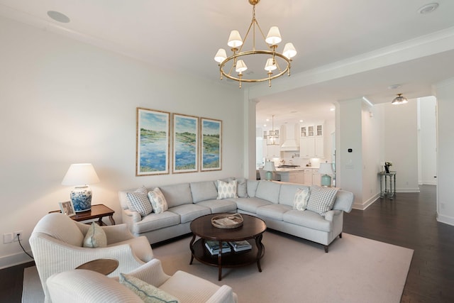 living area featuring crown molding, baseboards, an inviting chandelier, and dark wood-type flooring
