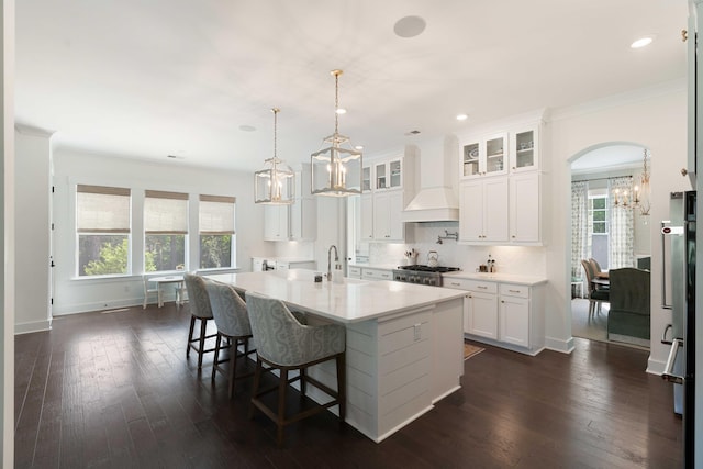 kitchen featuring light countertops, white cabinetry, a chandelier, and premium range hood