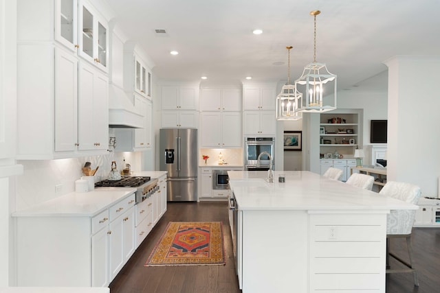 kitchen featuring white cabinetry, a kitchen breakfast bar, a notable chandelier, and stainless steel appliances
