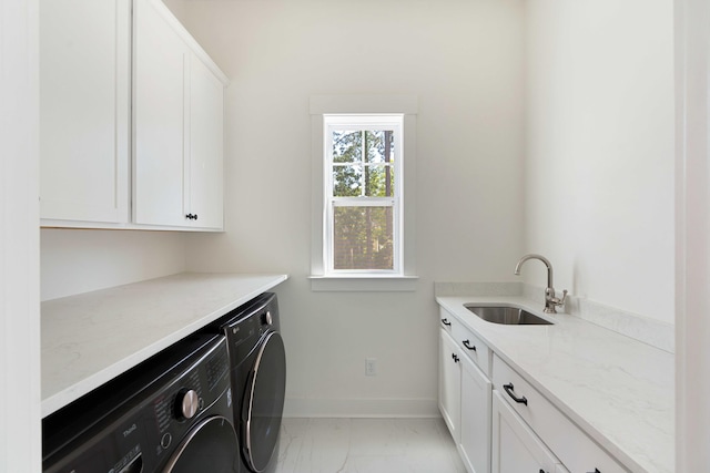 washroom featuring cabinet space, a sink, baseboards, marble finish floor, and washer and dryer