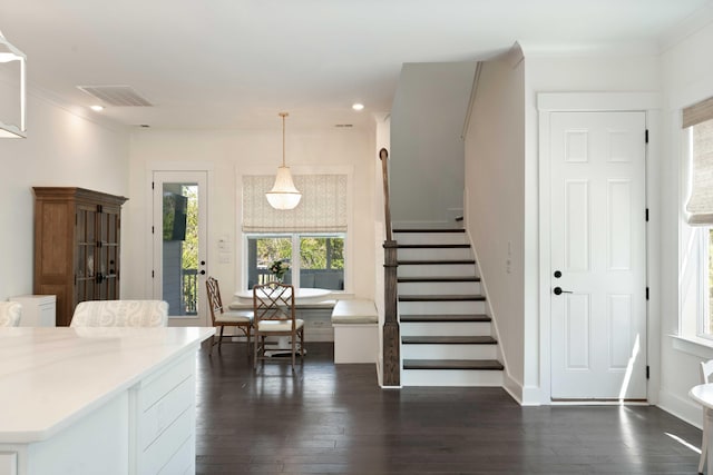 kitchen with light countertops, ornamental molding, dark wood-style floors, and visible vents