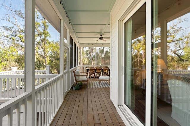unfurnished sunroom with a ceiling fan and outdoor dining space