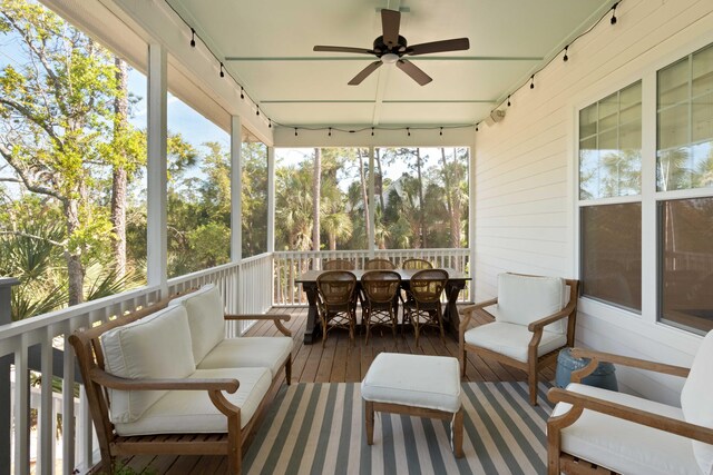 sunroom / solarium featuring a ceiling fan, outdoor dining area, and rail lighting