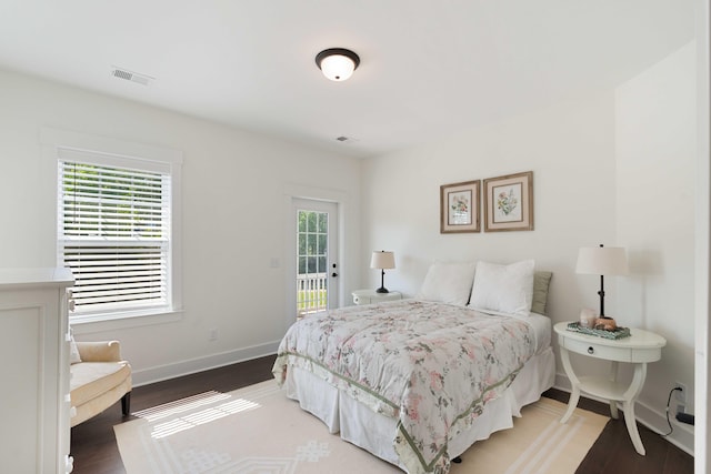 bedroom featuring baseboards, visible vents, access to exterior, and wood finished floors