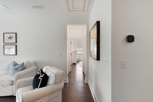 corridor with visible vents, baseboards, and dark wood-type flooring