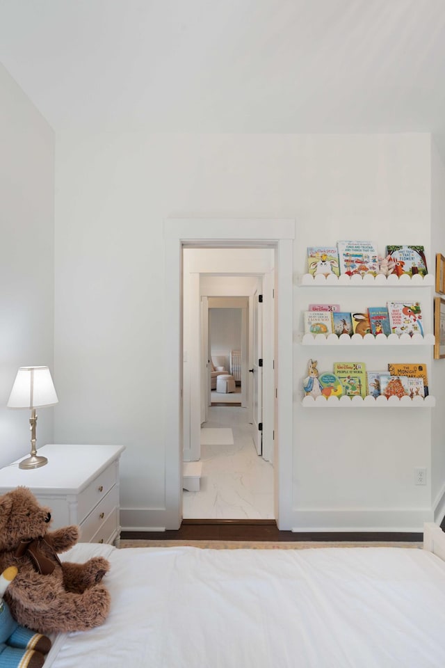 bedroom featuring baseboards and marble finish floor